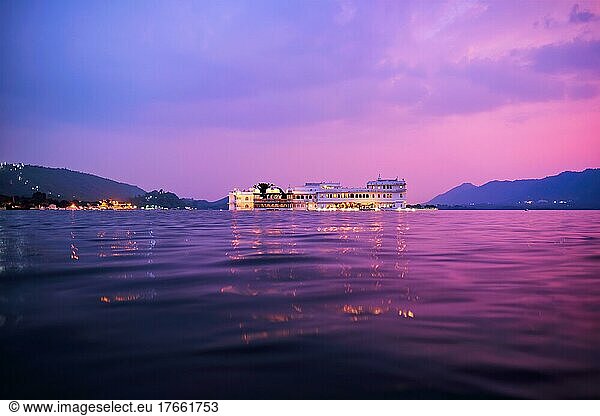 Romantic luxury India travel tourism  Lake Palace (Jag Niwas) complex on Lake Pichola on sunset in twilight with dramatic sky  Udaipur  Rajasthan  India