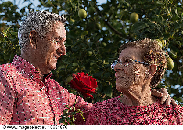 Romantic senior couple with flowers in garden