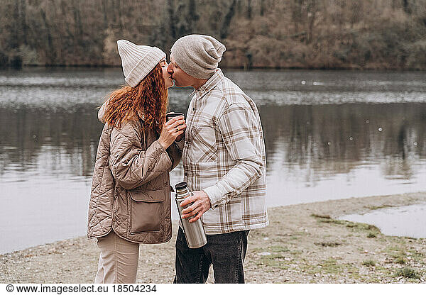 Romantic walk of a couple in a springtime park on the banks of river