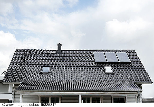 Rooftop of one-family house with three solar panels  Germany