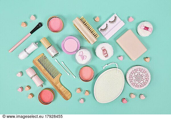 Rosa Make-up Beauty-Produkte wie Pinsel  Puder oder Lippenstift auf teal blauen Hintergrund