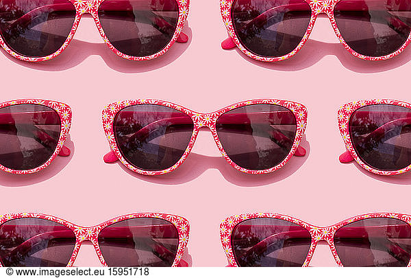 Rosa Retro-Sonnenbrille vor pastellrosa Hintergrund