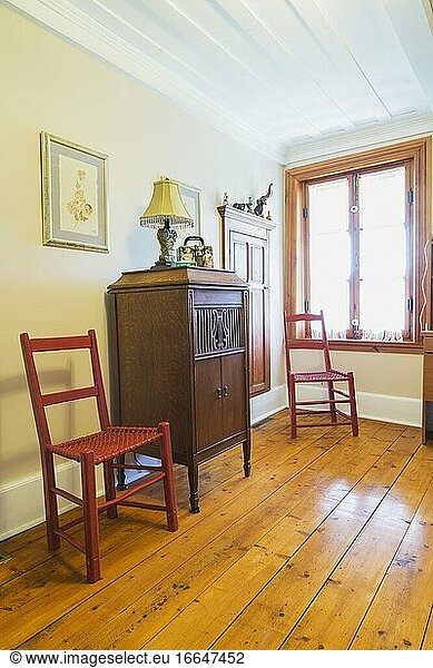 Rot gestrichene Stühle aus geflochtenem Rohleder in einem Heimbüro in einem alten Haus im kanadischen Stil um 1840  Quebec  Kanada. Dieses Bild ist freigegebenes Eigentum. CUPR0361.