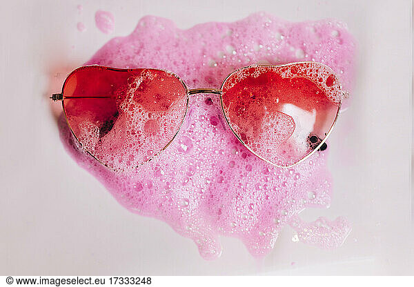 Rote Herzform Sonnenbrille auf rosa Seife sud über weißem Hintergrund