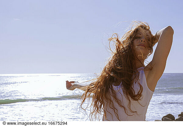 Rothaarige Frau am windigen Strand