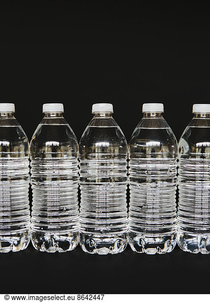 Row of clear  plastic water bottles filled with filtered water