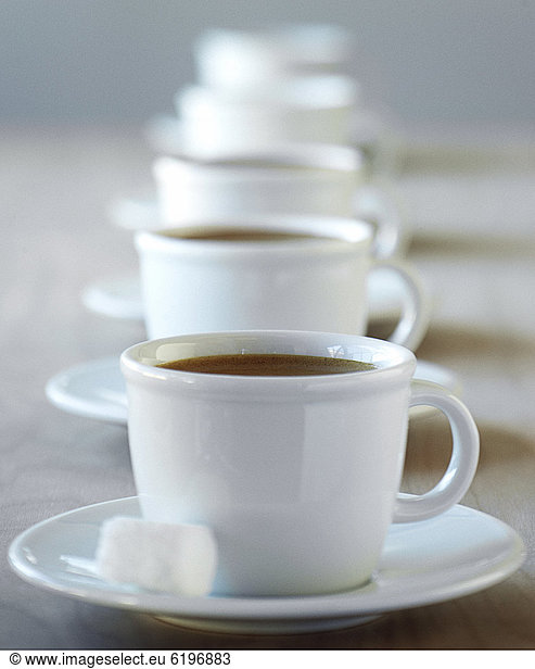 Row of coffee cups on saucers