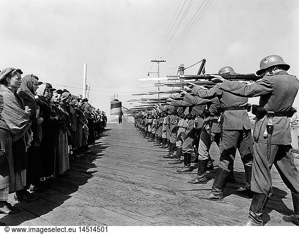 Row of German Soldiers with Rifles and Bayonets aimed at Norwegian Prisoners  on-set of the Film  Edge of Darkness  1943