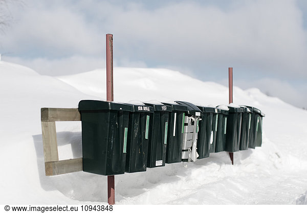 Row of mail boxes on snow covered field