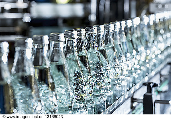 Row of mineral water bottles on conveyor belt
