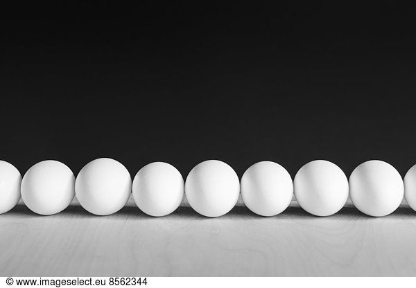 Row of white  free range  organic eggs  black background