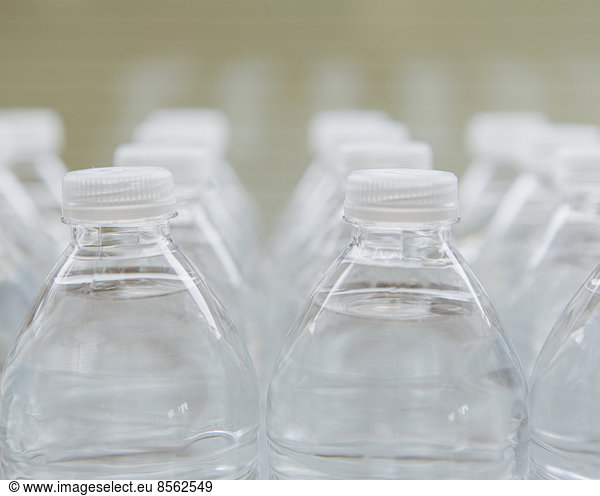 Rows of water-filled plastic bottles with screw caps.
