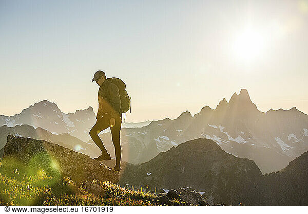 Rucksacktourist wandert auf einem malerischen Bergrücken in Richtung Gipfel.