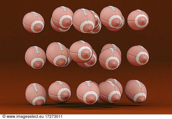 Rugby balls levitating against red background