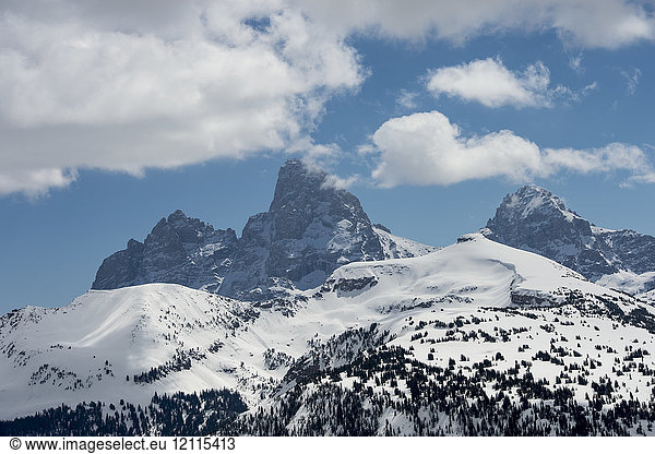 Rugged mountain peaks on a landscape covered in snow with blue sky and cloud  Peace Park; Wyoming  United States of America