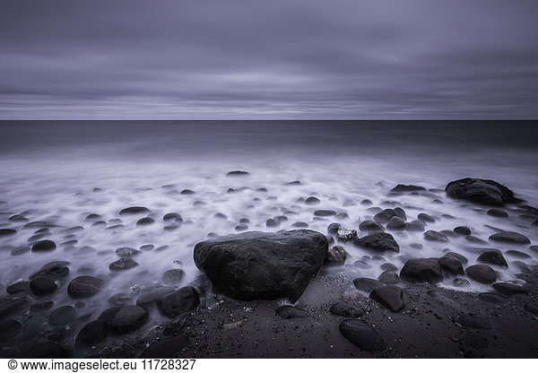 Ruhig bewölktes graues Meer und Felsen am Strand  Kalundborg  Dänemark
