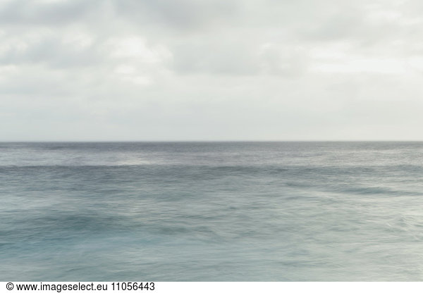 Ruhiges Ozeanwasser und bedeckter Himmel