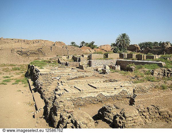 Ruinen eines ptolemäischen Gebäudes im Vordergrund  im Hintergrund die Umfassungsmauer aus Lehmziegeln.