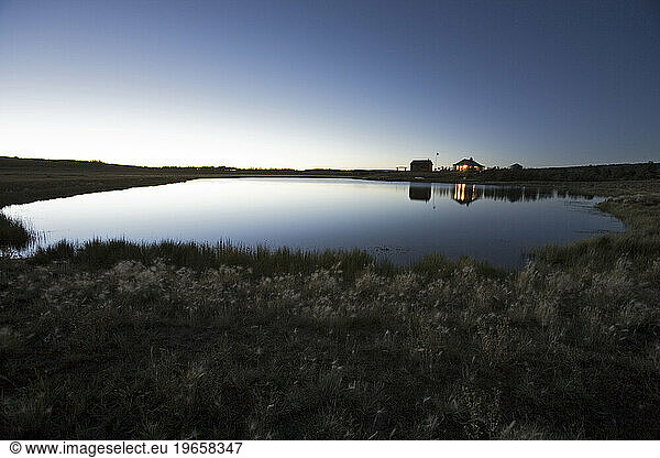 Rural buildings and pond at dusk on the Uncompahgre plateau  Colorado.