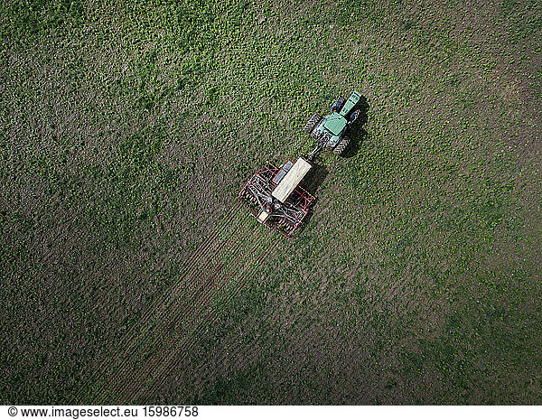 Russia  Aerial view of tractor plowing green field
