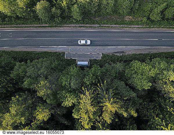 Russia  Leningrad Oblast  Tikhvin  Aerial view of car stopped at remote bus stop in middle of vast green forest