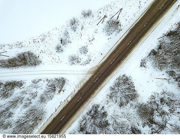 Russia  Moscow Oblast  Aerial view of bare trees surrounding empty countryside highway in winter