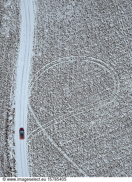 Russia  Moscow Oblast  Aerial view of car driving along country road past snow-covered fields