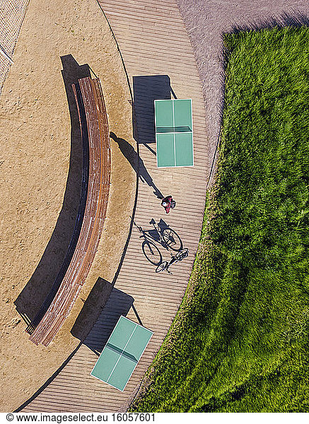 Russia  Tikhvin  Man with bicycle on boardwalk with table tennis tables  aerial view
