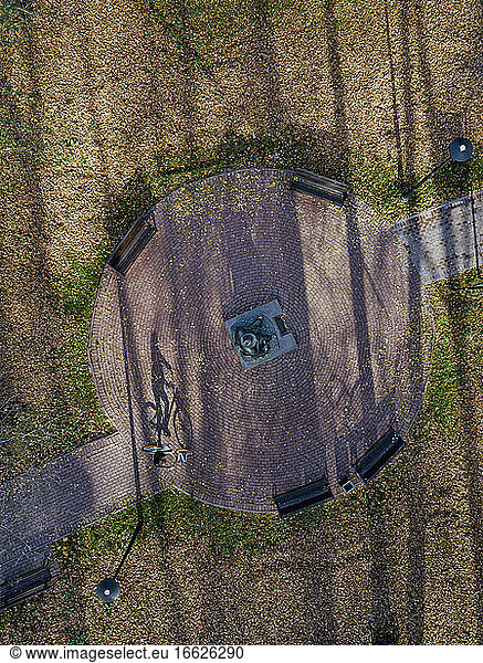 Russland  Moskauer Gebiet  Sergijew Posad  Luftaufnahme einer Radfahrerin  die am Denkmal für Michail Prischwin im Herbstpark vorbeifährt