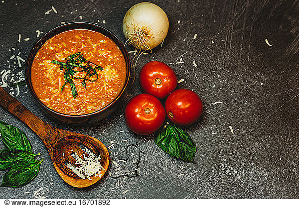 Rustic tomato basil soup onion tomato wood spoon cheese melted warm
