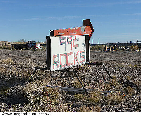 Rusty roadside sign advertising a reststop  deserted trucks and rubbish.