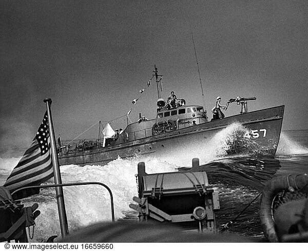 Südpazifik  um 1943
Ein U-Boot der US-Küstenwache auf Konvoi-Patrouille  das an einem anderen Patrouillenboot der Küstenwache vorbeifährt  das an seinem Heck mit Wasserbomben beladen ist.