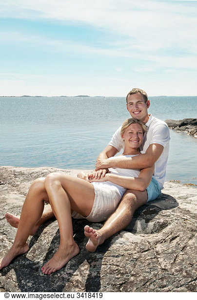 Süßes Paar am Strand sitzend