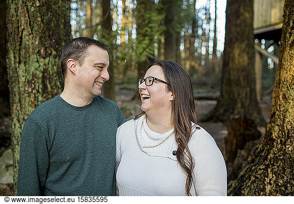 Süßes Paar  das im Wald miteinander lacht.