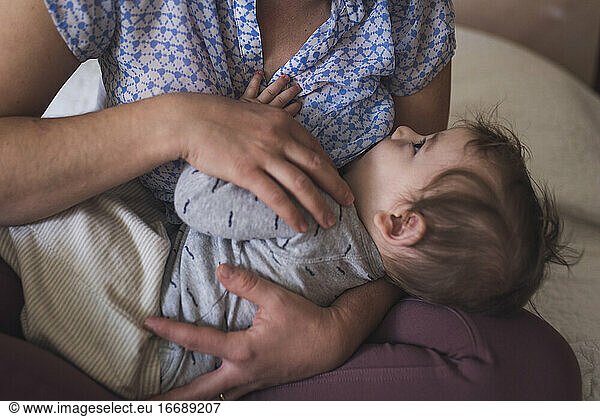 Säugling  der seine Mutter beim Stillen zufrieden anschaut