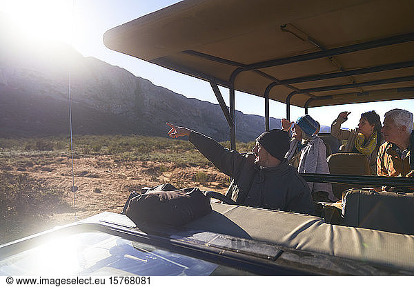 Safari-Guide und Gruppe im sonnigen Geländewagen