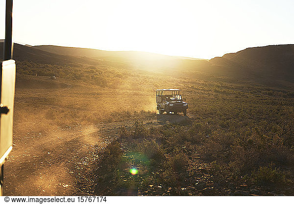 Safari off-road vehicle driving on sunny dirt road South Africa