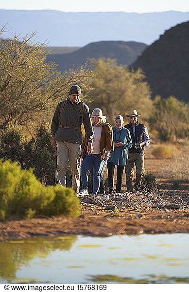 Safari-Reiseleiter führt Gruppe durch sonniges Wildschutzgebiet