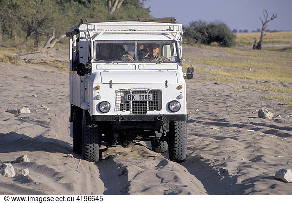 Safari Truck faehrt durch tiefen Sand Botswana