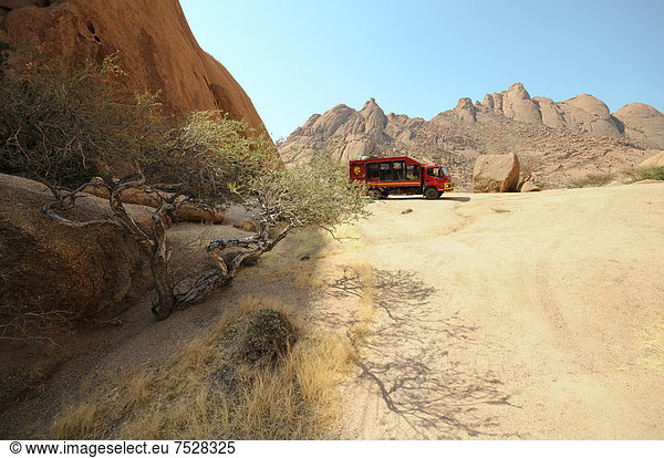 Safaritruck Savannenlandschaft mit Granitfelsen der Pontok Berge Spitzkoppe