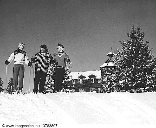 Saint-Sauveur  Quebec  Canada: c. 1955 Three skiers in front of Nymark´s Lodge in the Laurentian Mountain resort town of Saint-Sauveur in Quebec.