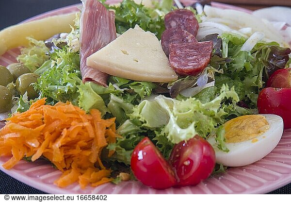 Salat auf rosa Teller nach spanischer Art.