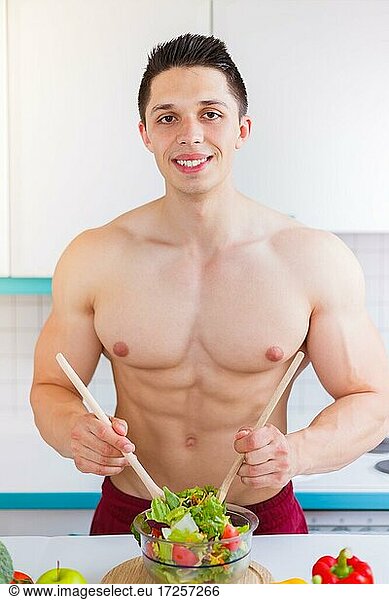 Salat zubereiten essen Mann Bodybuilder Mittagessen Küche gesunde Ernährung vertikal in Deutschland