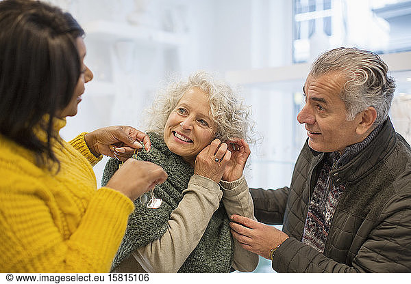 Sales assistant helping senior couple jewelry shopping