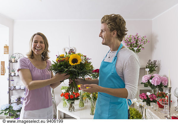 Salesman with customer in flower shop  smiling