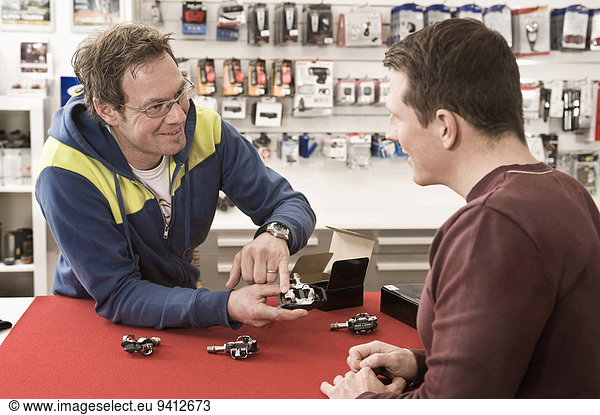 Salesperson explaining bicycle spare parts