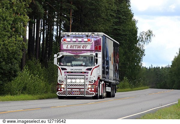 Salo  Finland - August 5  2018. Headlights of beautifully customised red and white Scania R580 truck of L. Retva on dark rural highway.