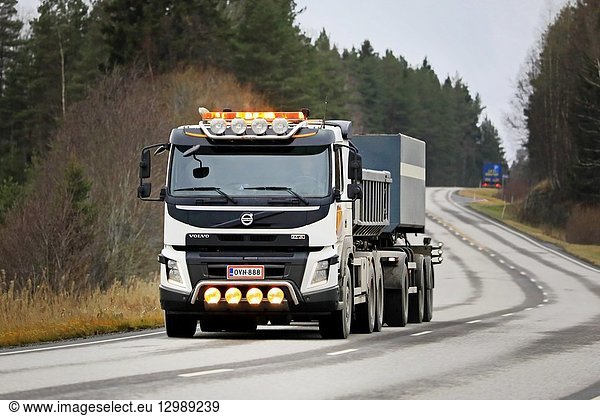 Salo  Finland - November 9  2018: White Volvo FMX gravel truck hauling a load on highway with auxiliary lights on a rainy day in South of Finland.