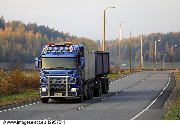 Salo  Finland - October 12  2018: Blue Scania truck of E Gustafsson Oy in seasonal sugar beet haul on autumnal highway at sunset in South of Finland.