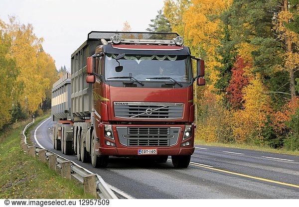 Salo  Finland - October 13  2018: Red Volvo FH 16 750 truck up front in seasonal sugar beet haul on rural highway flanked by autumn foliage.